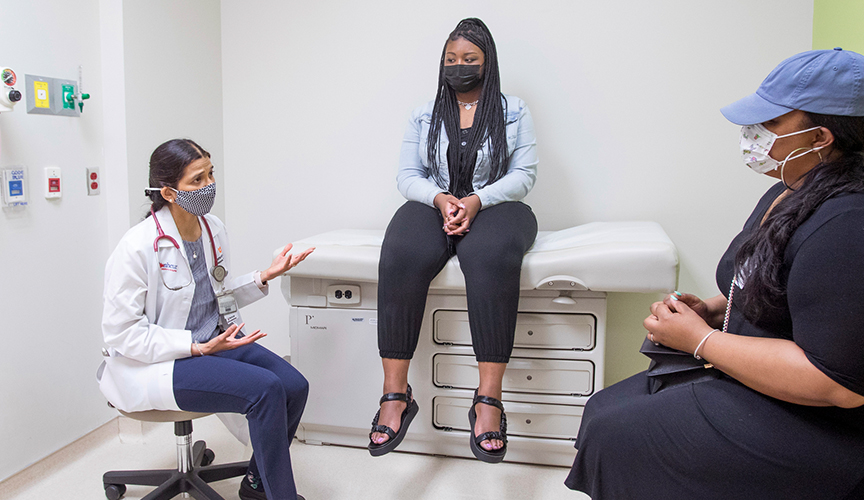 Le Bonheur neurologists consults with an MS patient and her family in clinic.